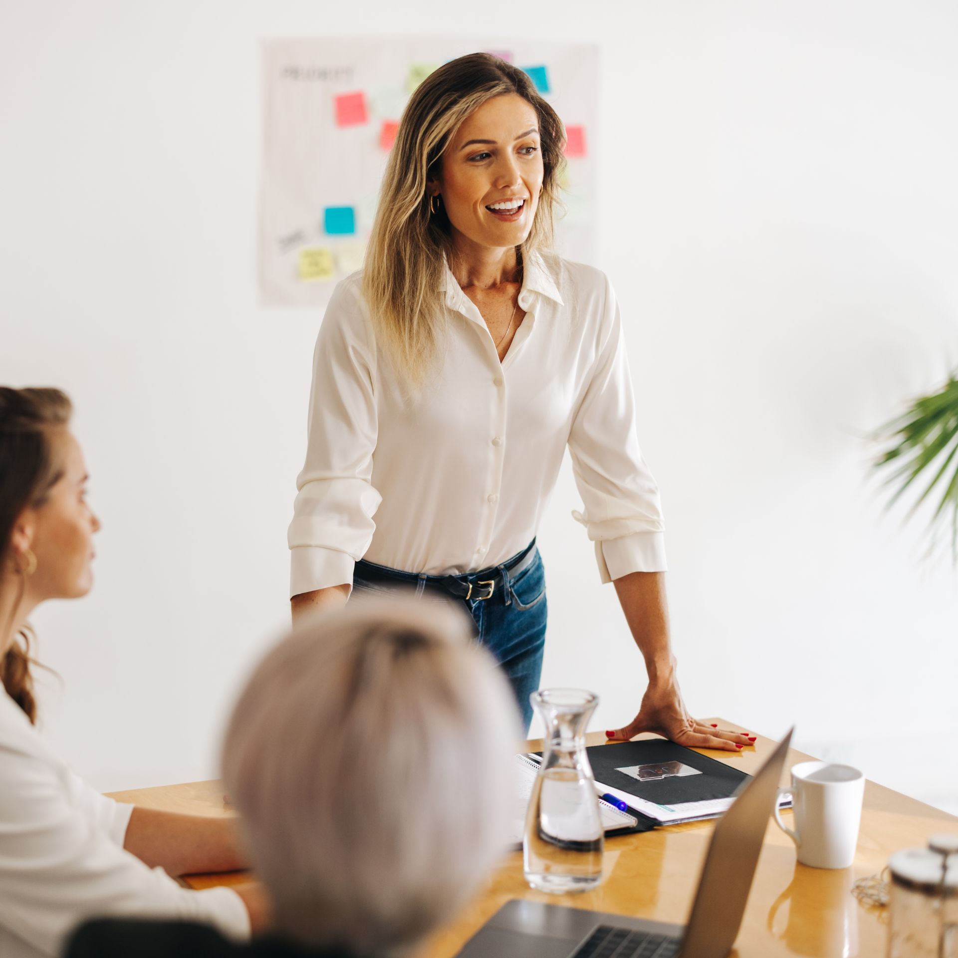 Professional woman leading a meeting with colleagues in a bright office.