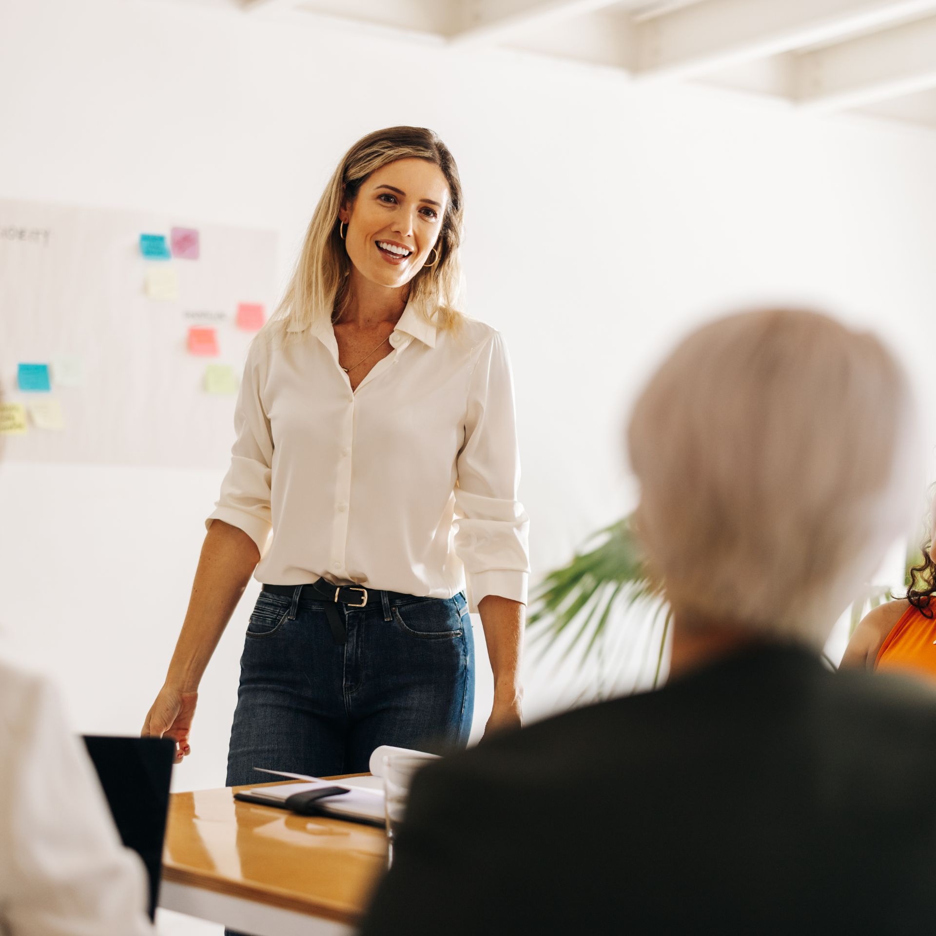 A woman confidently presenting in a meeting room.