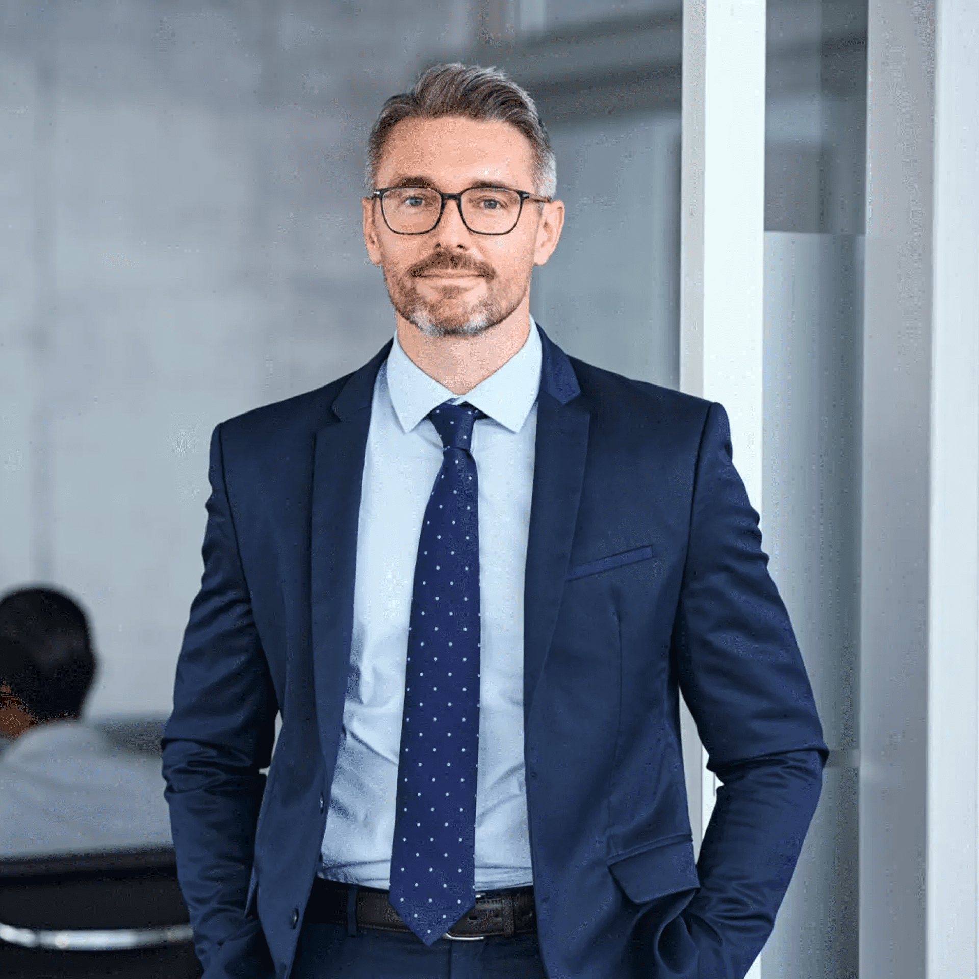 Confident businessman in a suit smiling indoors.