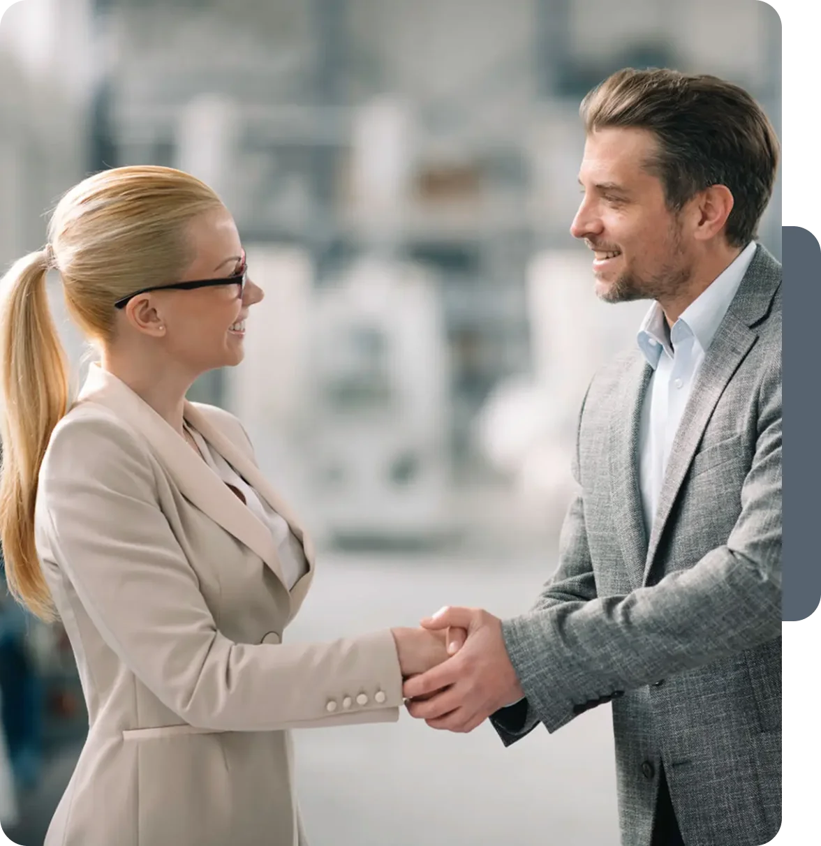 Two professionals shaking hands in an office setting.
